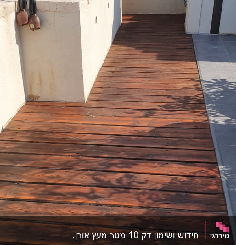 דק עץ חום עם מעקה מתכת על גג